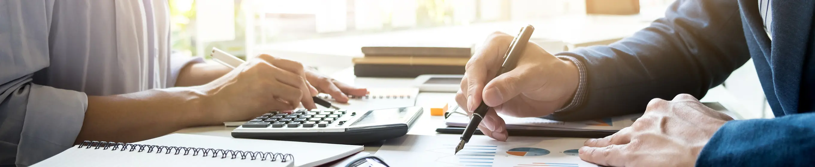 資料にメモを取り、電卓で計算をしている様子