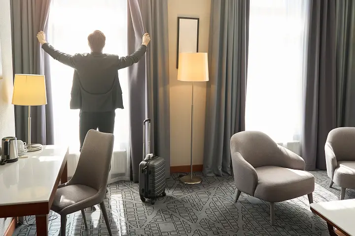 ホテルの部屋でカーテンを開いている様子
