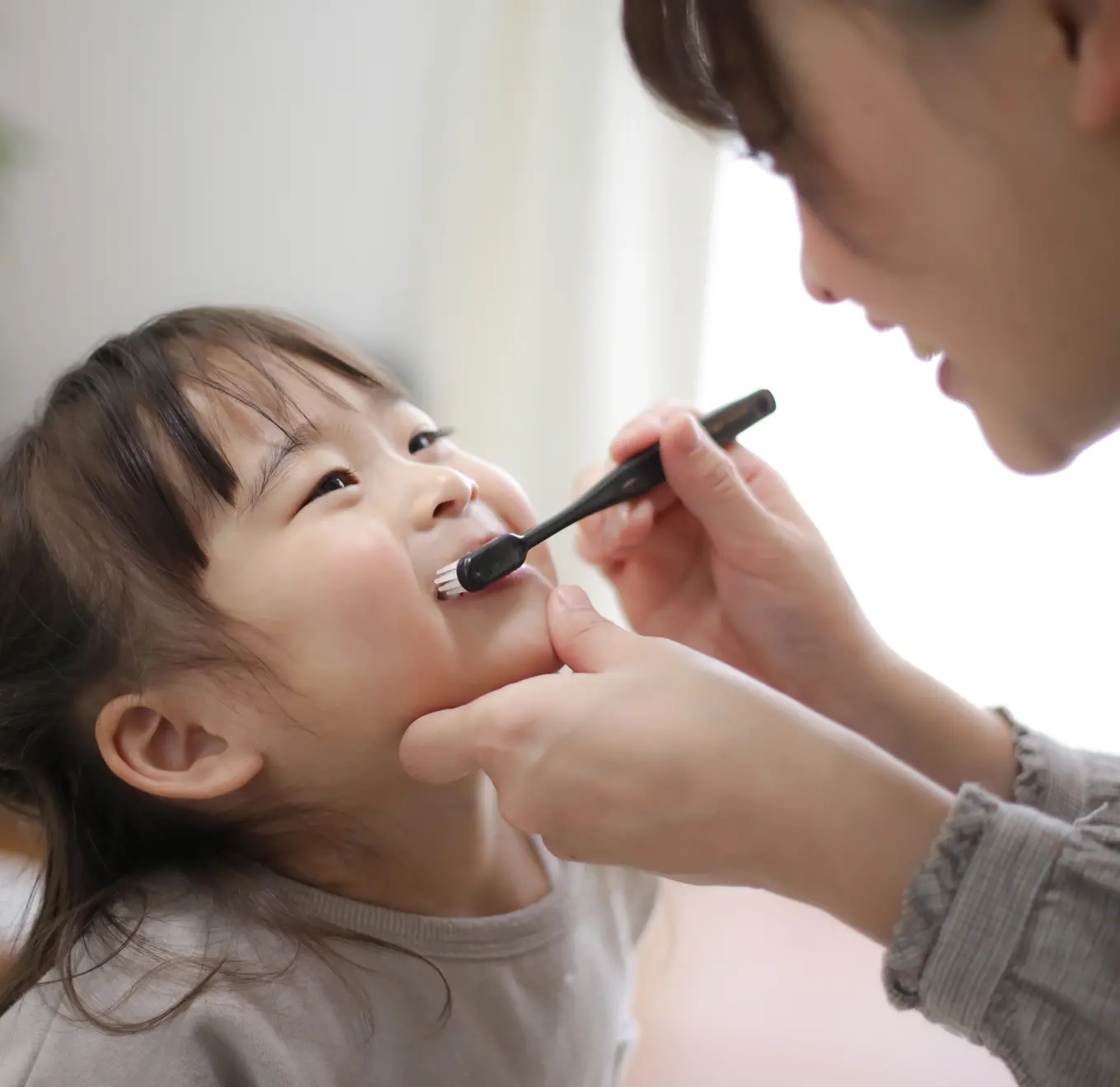 母親が子どもの歯を磨いている様子