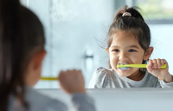 子どもが鏡を見ながら歯を磨いている様子